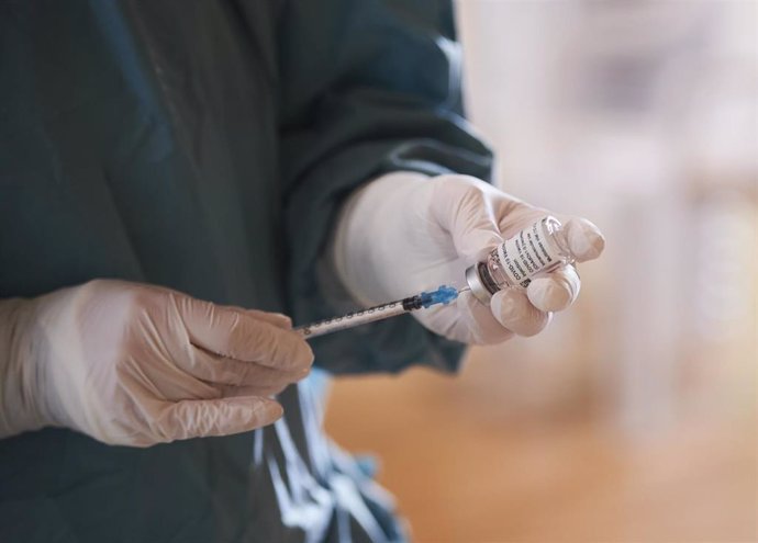 Archivo - Una profesional sanitaria sostiene un vial con la vacuna del Covid 