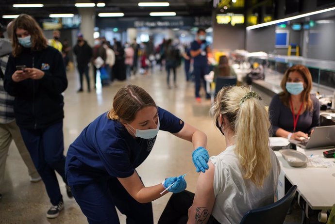 Archivo - 20 June 2021, United Kingdom, London: Rosi Stamp, 25, receives a dose of Pfizer BioNTech COVID-19 vaccine at an NHS Vaccination Clinic at Tottenham Hotspur's stadium. The NHS is braced for high demand as anyone in England over the age of 18 ca
