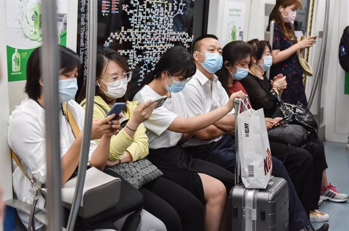 Un grupo de personas en un tranvía en la capital de China, Pekín, durante la pandemia de coronavirus