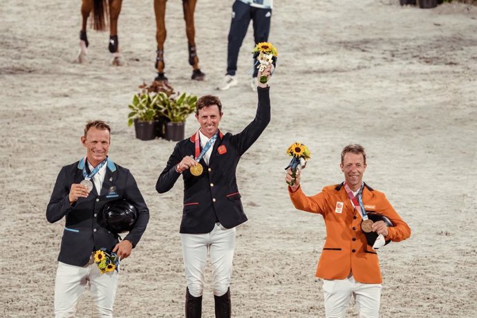 Great Britains Ben Maher celebrates his gold medal win in the Individual Showjumping Final at the Tokyo 2020 Olympic Games at the Baji Koen Equestrian Park. L to R: Peder Fredricson (SWE), Ben Maher (GBR), Maikel van der Vleuten (NED) (FEI/Christophe T