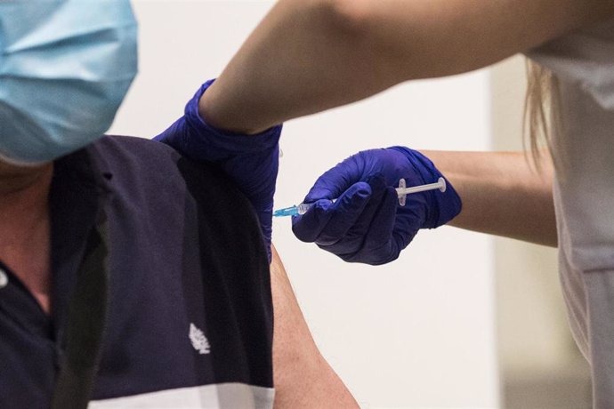 Archivo - Una sanitaria administra la primera dosis de la vacuna de Pfizer a un hombre, en el Hospital Universitario de Getafe