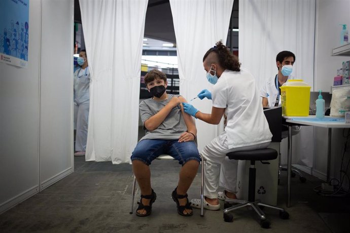 Un joven recibe la primera dosis de la vacuna contra la Covid-19 en la primera jornada disponible para la franja de 12 a 15 años, en Fira Barcelona