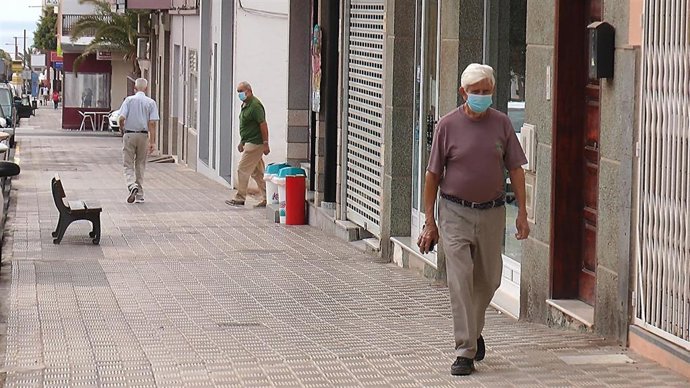 Archivo - Un hombre camina con mascarilla.