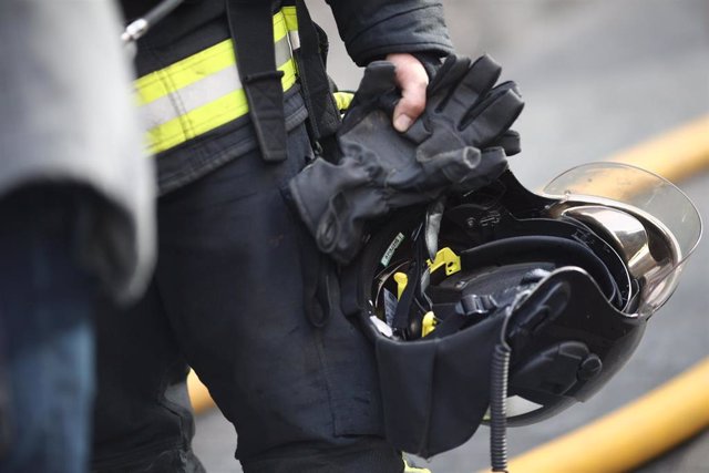 Archivo - Un bombero de Madrid lleva su casco y guantes