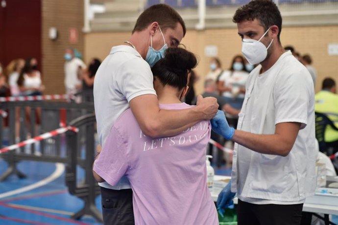 Una joven se abraza a un familiar tras ser vacunada de la primera dosis de la vacuna Moderna en las instalaciones del Pabellón Jara Carrillo, a 3 de agosto de 2021, en Alcantarilla, Murcia (España).