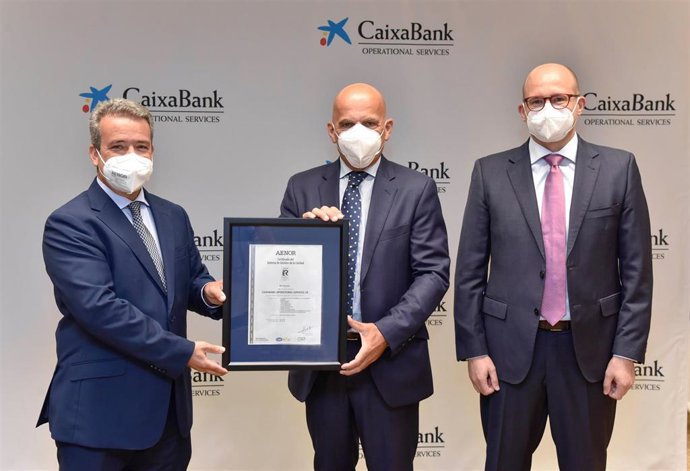 El Director De la Regió Mediterrnia D'Aenor, Ángel Luís Sánchez, Ha Lliurat Aquest Certificat Al Director General De Caixabank Operational Services, Fernando Rodríguez Baquero, I El Responsable De Qualitat De Cops, Josep Vaqué Valls.