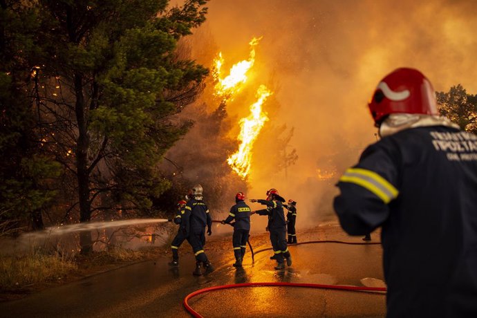 05 August 2021, Greece, Afidnes: Firefighters battle a forest fire approaching a gas station in a wooded area north of Athens. Photo: Angelos Tzortzinis/dpa