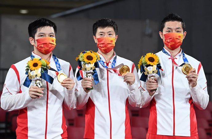 06 August 2021, Japan, Tokyo: Chinese gold medallist team of Zhendong Fan, Long Ma and Xin Xu, celebrate during the medal ceremony of the Men's Table Tennis Team gold medal match, as part of the Tokyo 2020 Olympic Games. Photo: Swen Pfrtner/dpa