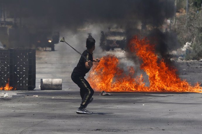 02 August 2021, Palestinian Territories, Nablus: A Palestinian protester hurls stones at Israeli security forces during clashes at the village of Beita near the West Bank's city of Nablus. Photo: Stringer/APA Images via ZUMA Press Wire/dpa