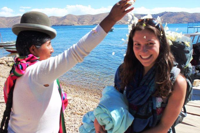 Una turista agasajada por una mujer indígena de Perú.