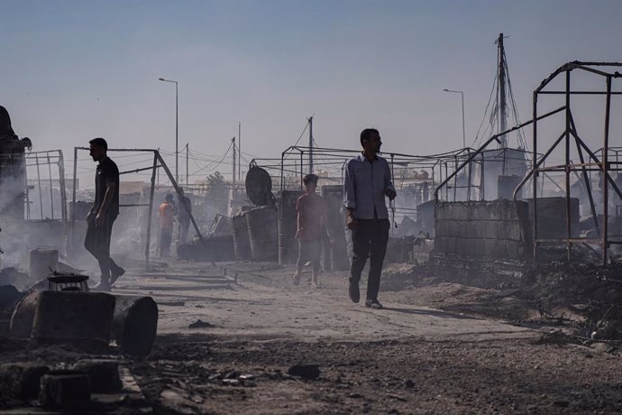 Archivo - 04 June 2021, Iraq, Sharya: People inspect their scorched tents following a massive blaze that swept through the Sharya Camp, which shelters Yezidi refugees in Iraq's northern autonomous region of Kurdistan. The blaze had gutted nearly 400 ten