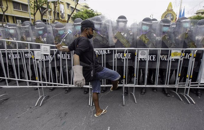 07 August 2021, Thailand, Bangkok: A demonstrator removes barricades in front of riot police officers during clashes at an anti-government rally in Bangkok. Photo: Chaiwat Subprasom/SOPA Images via ZUMA Press Wire/dpa