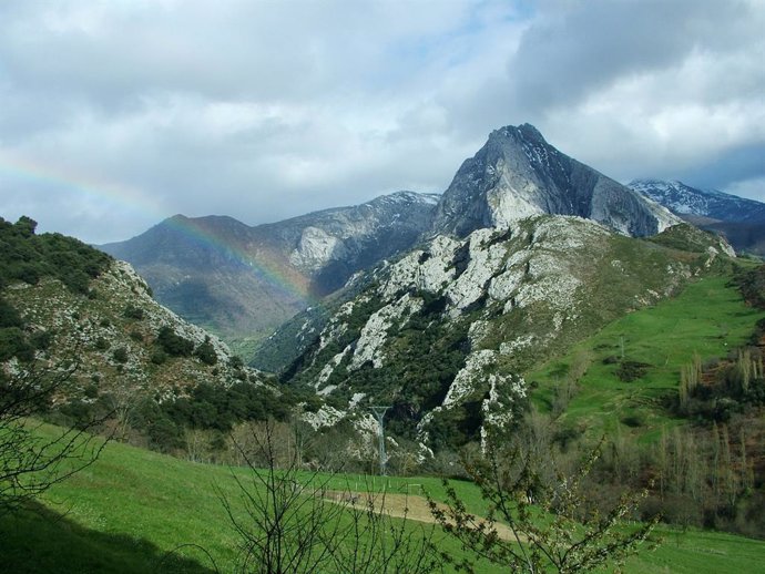 Archivo - Paisaje con montañas, nubes y arco iris