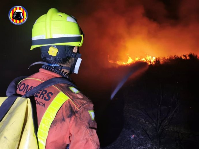 Un bombero del Consorcio Provincial de Valencia trabaja durante la noche del sábado para estabilizar el incendio forestal de Rafelguaraf
