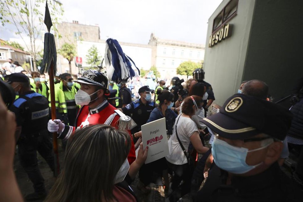 Asistentes a la lectura del pregón de las Fiestas de la Peregrina acuden a refugiarse a una cafetería cercana después de que una protesta de trabajadores de Ence haya interrumpido y boicoteado el acto, en Pontevedra, Galicia (España).