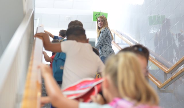 Archivo - Niños de Primaria se dirigen a su aula junto a una trabajadora del centro escolar