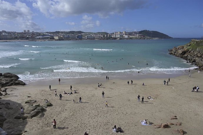 Archivo - Varias personas disfrutan de un día de playa