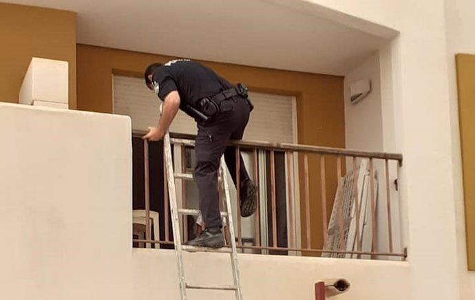 Un agente de la Policía Local de Vera accede al domicilio donde se encontraba la menor mediante una escalera.