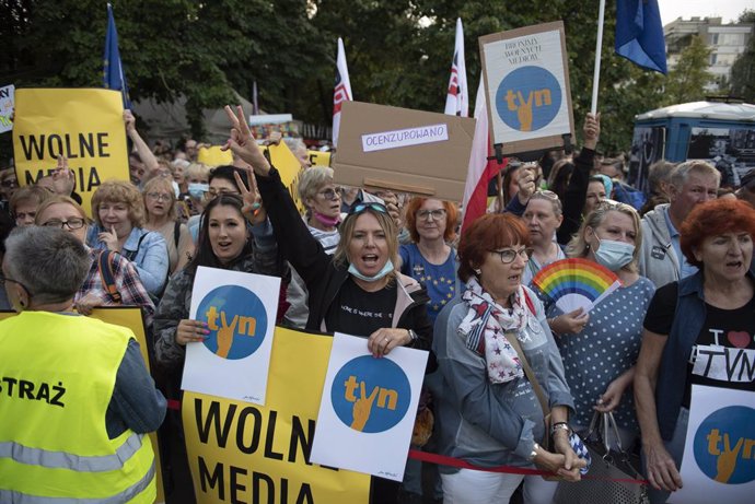 10 August 2021, Poland, Warsaw: People shout slogans and hold placards with the independent broadcaster TVN logo during a protest in front of the Polish Parliament (Sejm) as part of a nationwide protest against a proposed bill by the lawmakers of the ru