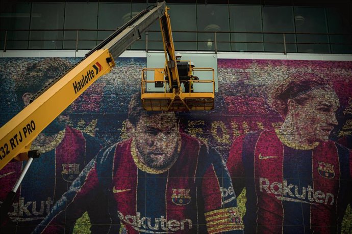10 August 2021, Spain, Barcelona: Workers on a crane remove a poster of Argentine footballer Lionel Messi from the facade of the Camp Nou Stadium after his departure from the club. Photo: Matthias Oesterle/ZUMA Press Wire/dpa