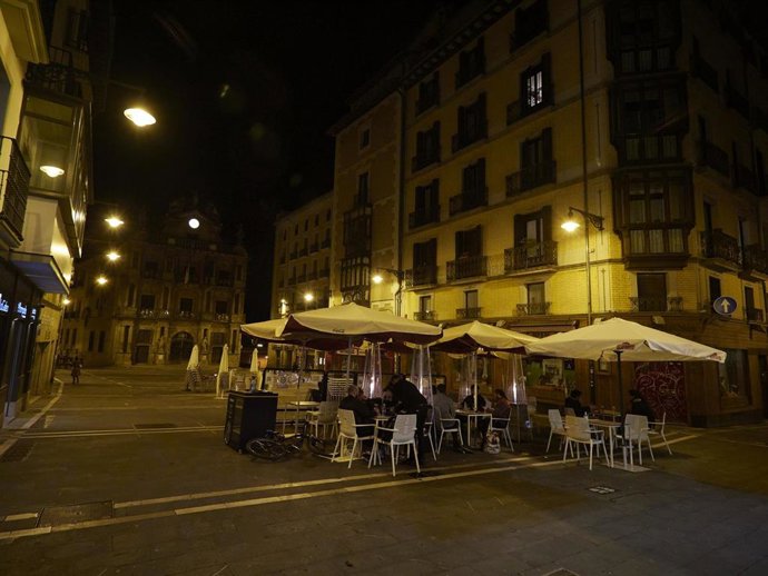 Archivo - Unos jovenes en una terraza de la plaza del ayuntamiento de Pamplona alrededor de la media noche