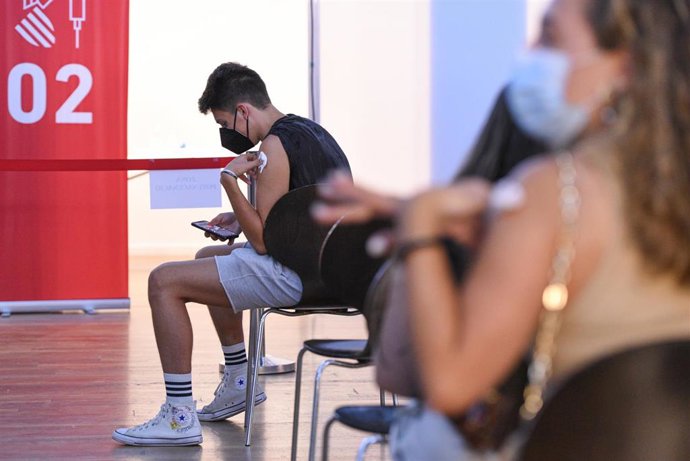 Un adolescente espera en una sala, después de recibir la primera dosis de la vacuna Pfizer en el punto de vacunación de Xátiva, situado en el Hogar de los Jubilados, a 10 de agosto de 2021, en Xátiva, Valencia, Comunidad Valenciana (España).