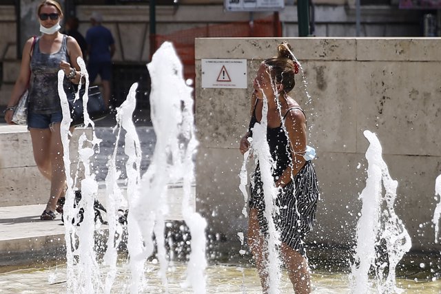 11 August 2021, Italy, Rome: A woman enjoys the water at the Arac Pacis fountain during a hot weather. Photo: Cecilia Fabiano/LaPresse via ZUMA Press/dpa