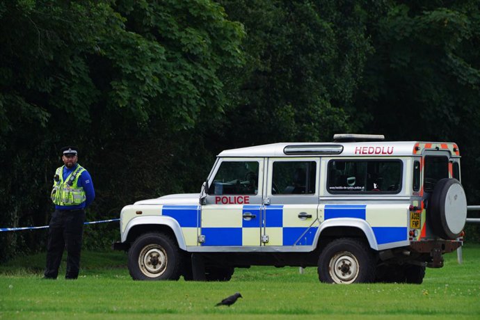 03 August 2021, United Kingdom, Bridgend: A police officer stands at a cordoned-off crime scene, where a five-year-old boy was found dead in the Ogmore River on Saturday. Photo: Ben Birchall/PA Wire/dpa