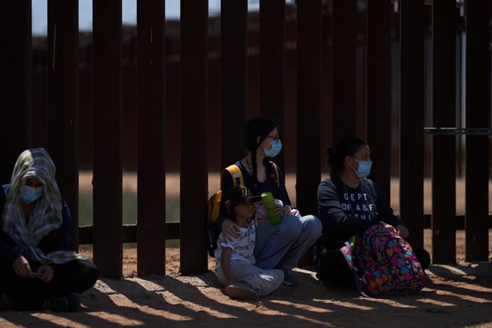 Archivo - Migrantes solicitantes de asilo se entregan a la Patrulla Fronteriza de Estados Unidos en el muro con México en Yuma. 