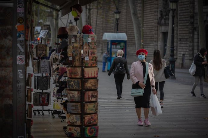 Archivo - Una mujer frente a una tienda de artículos turísticos en Barcelona, Catalunya (España)