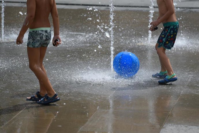 Dos niños juegan en una fuente del Parc Central, a 12 de agosto de 2021, en Valencia, Comunidad Valenciana (España). Como consecuencia de la ola de calor que comenzó ayer en toda España, la Comunitat Valenciana alcanzará durante la jornada de este jueve
