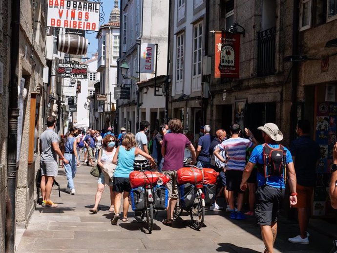 Varios peregrinos caminan con su bicicleta por la Rua do Franco de Santiago