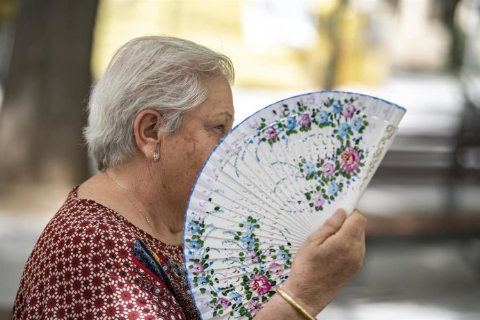 Una mujer agita su abanico ante el calor.