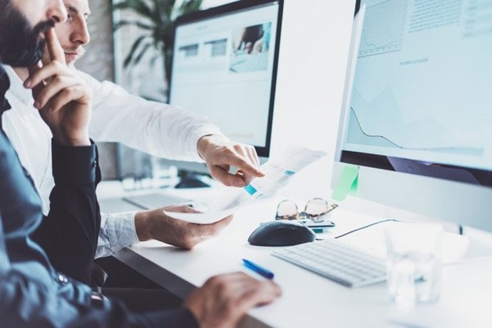 Archivo - Personas trabajando con ordenadores