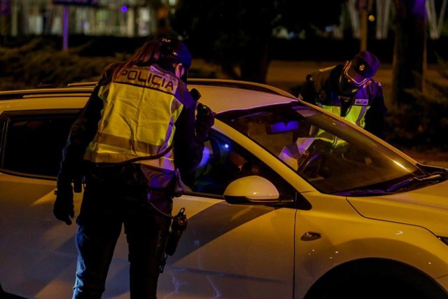 Archivo - Un policía nacional para a un coche en un control policial.