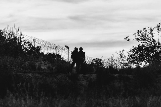 Archivo - Imagen de archivo de dos agentes de policía, frente a la frontera que separa Melilla y Marruecos, a 21 de mayo de 2021, en Marruecos
