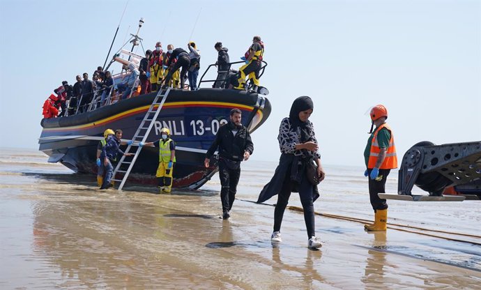 20 July 2021, United Kingdom, Dungeness: A group of people thought to be migrants crossing from France are brought ashore by the local lifeboat at Dungeness, after a small boat incident in the English Channel. Photo: Gareth Fuller/PA Wire/dpa
