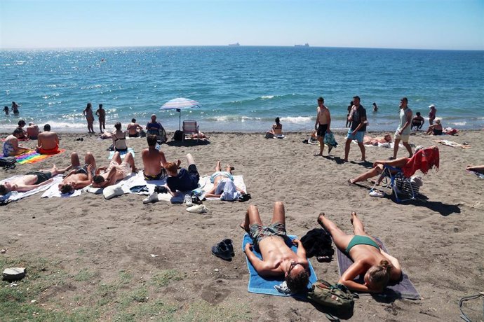 Bañistas y turistas disfrutan de un día en la playa de La Malagueta