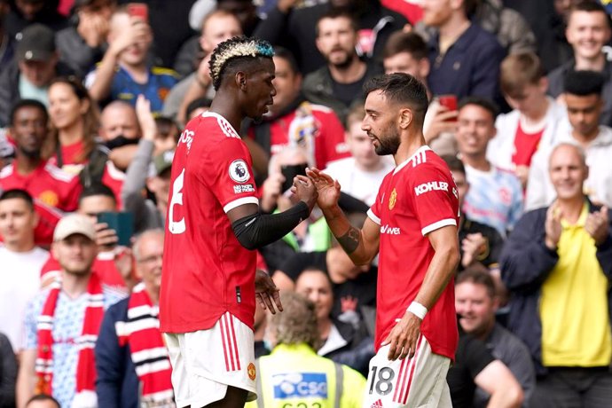 14 August 2021, United Kingdom, Manchester: Manchester United's Bruno Fernandes (R) celebrates scoring their side's first goal of the game with teammate Paul Pogba during the English Premier League soccer match between Manchester United and Leeds United