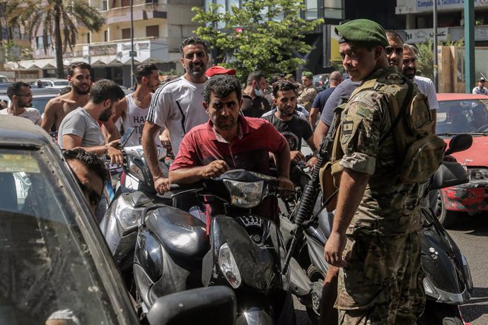 14 August 2021, Lebanon, Beirut: A Lebanese army soldier supervises entry of motorists and vehicles at a gas station in Beirut to curb fuel hoarding, as central bank chief Riad Salamehannounced this week that he would no longer be able to subsidize fue