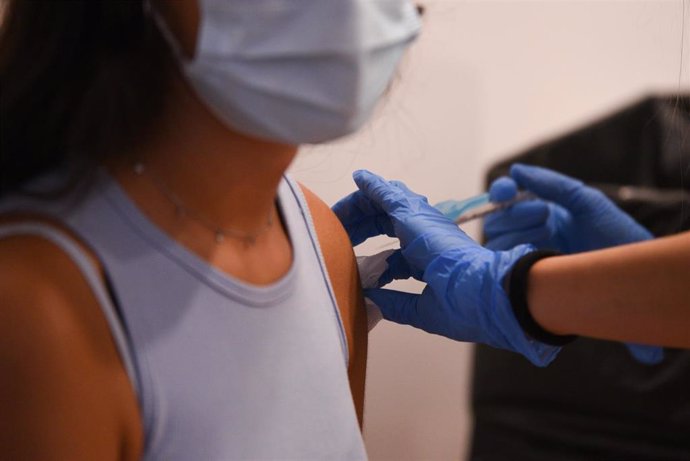 Una adolescente recibe la primera dosis de la vacuna Pfizer en un punto de vacunación 