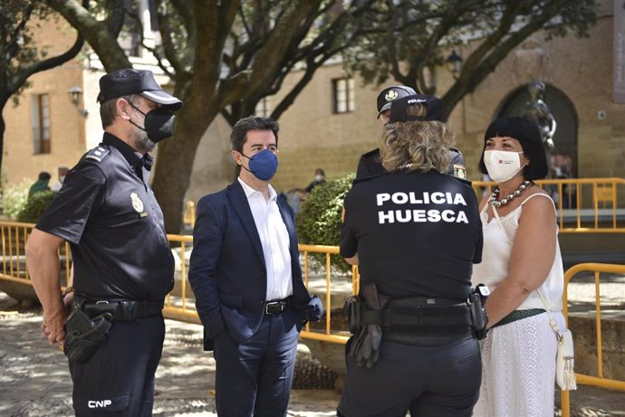 El alcalde de Huesca, Luis Felipe, y la cuarta teniente alcalde, Ana Loriente Bolaños, mantienen una conversación con varios agentes de Policía Nacional, en las inmediaciones de la Catedral, el día que hubieran comenzado las fiestas de San Lorenzo 2021.
