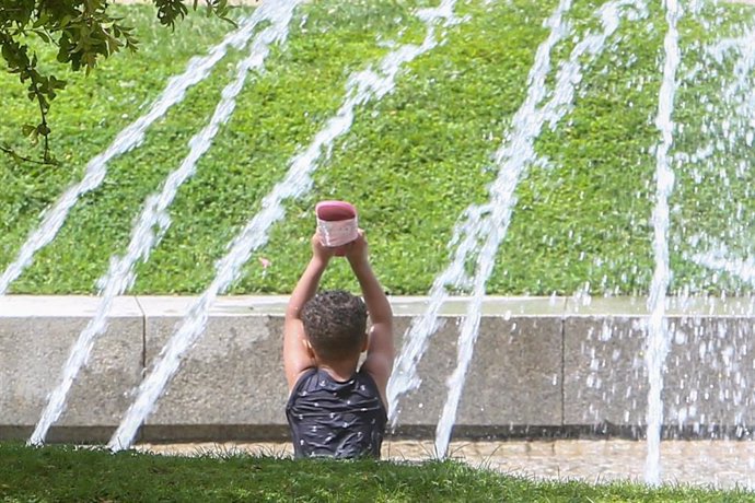 Un niño en una fuente en un parque.