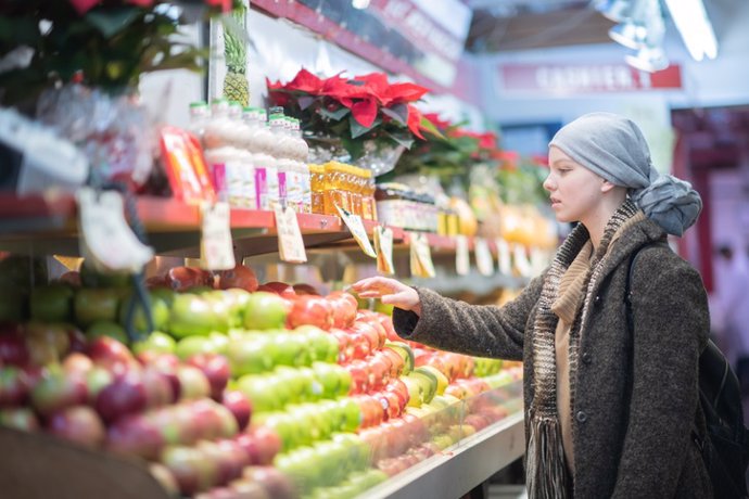 Archivo - Mujer con cáncer en el mercado comprando fruta.