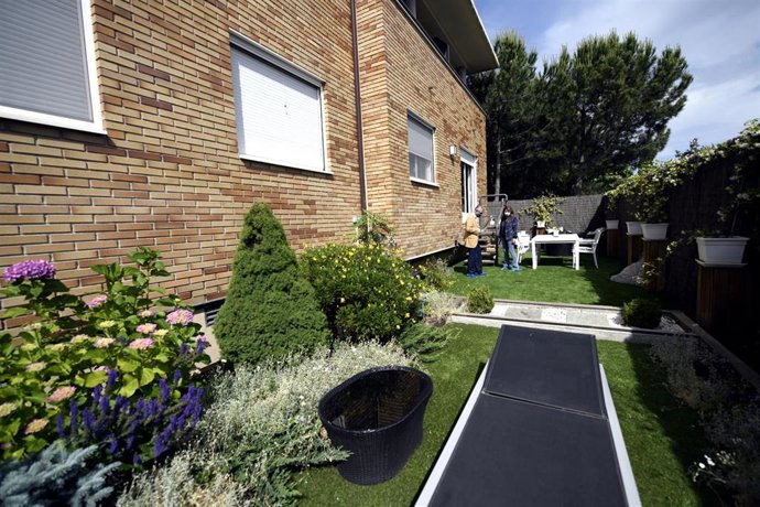 Archivo - El director de una inmobiliaria le enseña el jardín de una casa a una clienta, en una imagen de archivo.