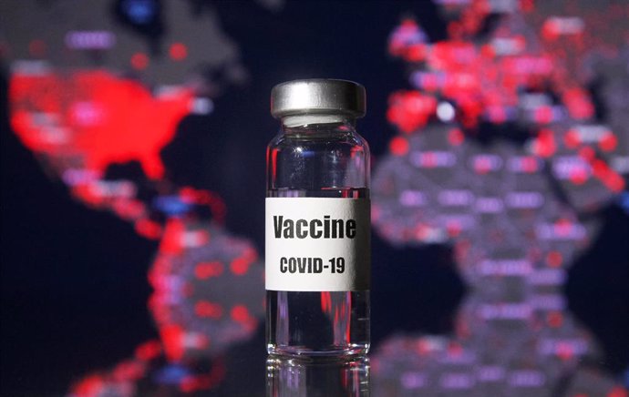 Archivo - 21 November 2020, Ukraine, ---: A vial written on it coronavirus (COVID-19) vaccine is pictured in front of a map of the COVID-19 cases of the world.