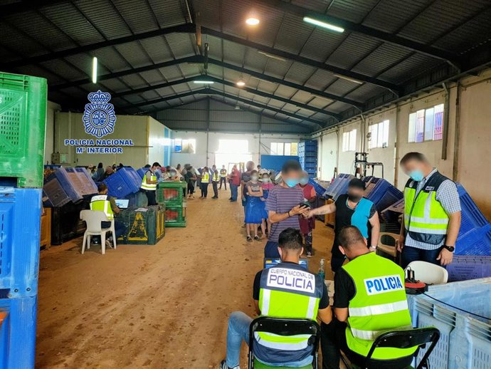 Agentes junto a algunos de los trabajadores del almacén