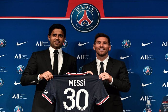 11 August 2021, France, Paris: Paris Saint-Germain's Qatari President Nasser Al-Khelaifi (L) poses along side Argentinian football player Lionel Messi as he holds-up his number 30 jersey during a press conference at the French football club Paris Saint-