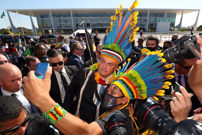 HANDOUT - 12 August 2021, Brazil, Brasilia: Brazilian President Jair Bolsonaro (C) poses for a selfie with indigenous accessories as he arrives for a meeting with indigenous representatives. Photo: Isac Nobrega/Palacio Planalto/dpa - ATENCIÓN: Sólo para