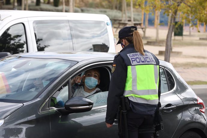 Archivo - Una agente de la Policía Nacional habla con una conductora durante un control policial